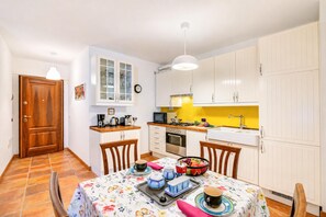 A compact kitchen with a dining area, featuring cabinets, a sink, and a microwave. - La Madonnina Apartment for 2 in Tenno (Tenno)