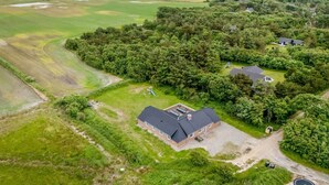 An aerial view of a rural property with a large house surrounded by fields and trees.