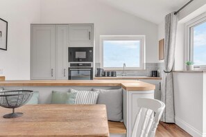 Enjoy cooking in this well-equipped kitchen with oven and microwave, adjacent to a dining and seating area.