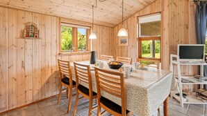 A wooden interior with a dining table, chairs, a coffee table, a laptop on a shelf, and a window with a view of greenery. - "Åsa" - 500m to the fjord by Interhome (Tarm)