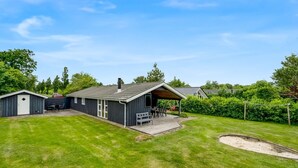 A residential property with a large lawn, a wooden deck, a covered outdoor seating area, and a garage. - "Åsa" - 500m to the fjord by Interhome (Tarm)