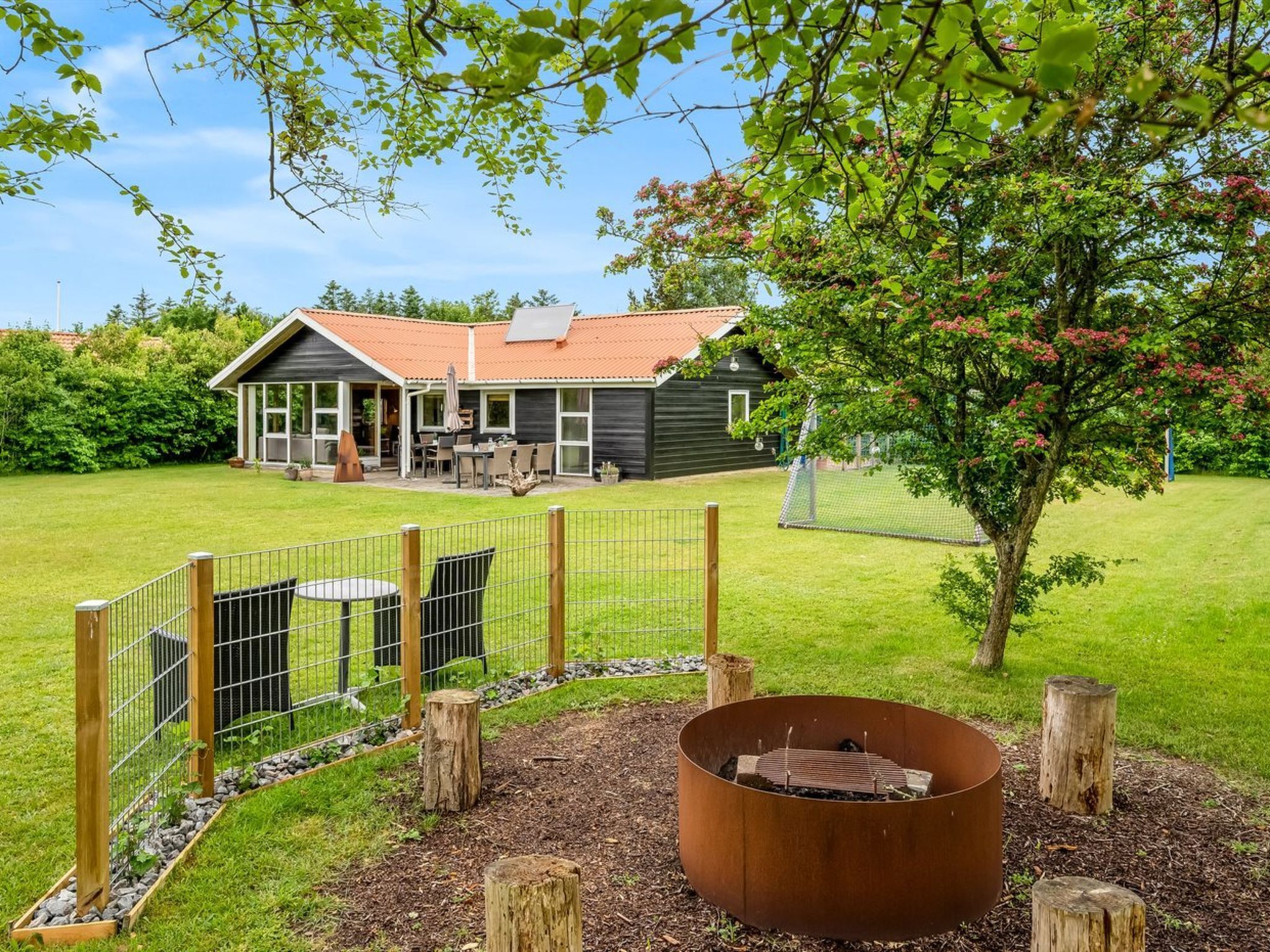 A house with a patio area, a fire pit, and a fenced yard.