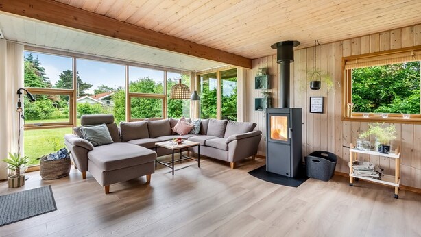 Ein gemütliches Wohnzimmer mit Sofa, Couchtisch und Kaminofen.