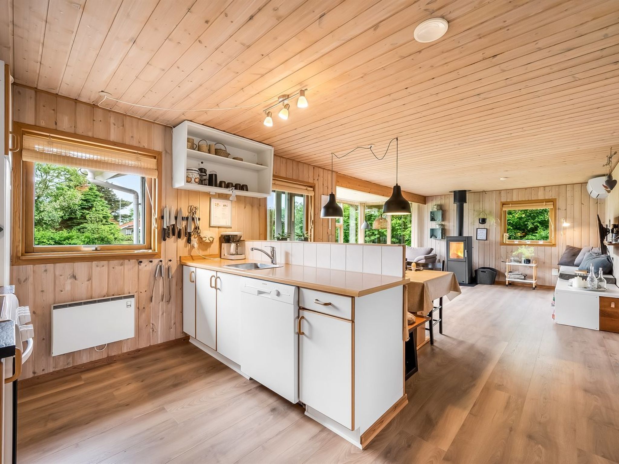 A modern kitchen with wooden cabinetry, a central island, and pendant lighting.