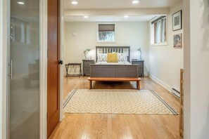 A bedroom with a bed, bedside tables, a nightstand, a bench, and a patterned rug. - #StayinMyDistrict Alberta Arts Daylight Studio (Portland)