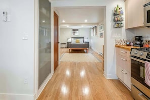 A modern kitchen with a stove, oven, and a wall-mounted spice rack. - #StayinMyDistrict Alberta Arts Daylight Studio (Portland)