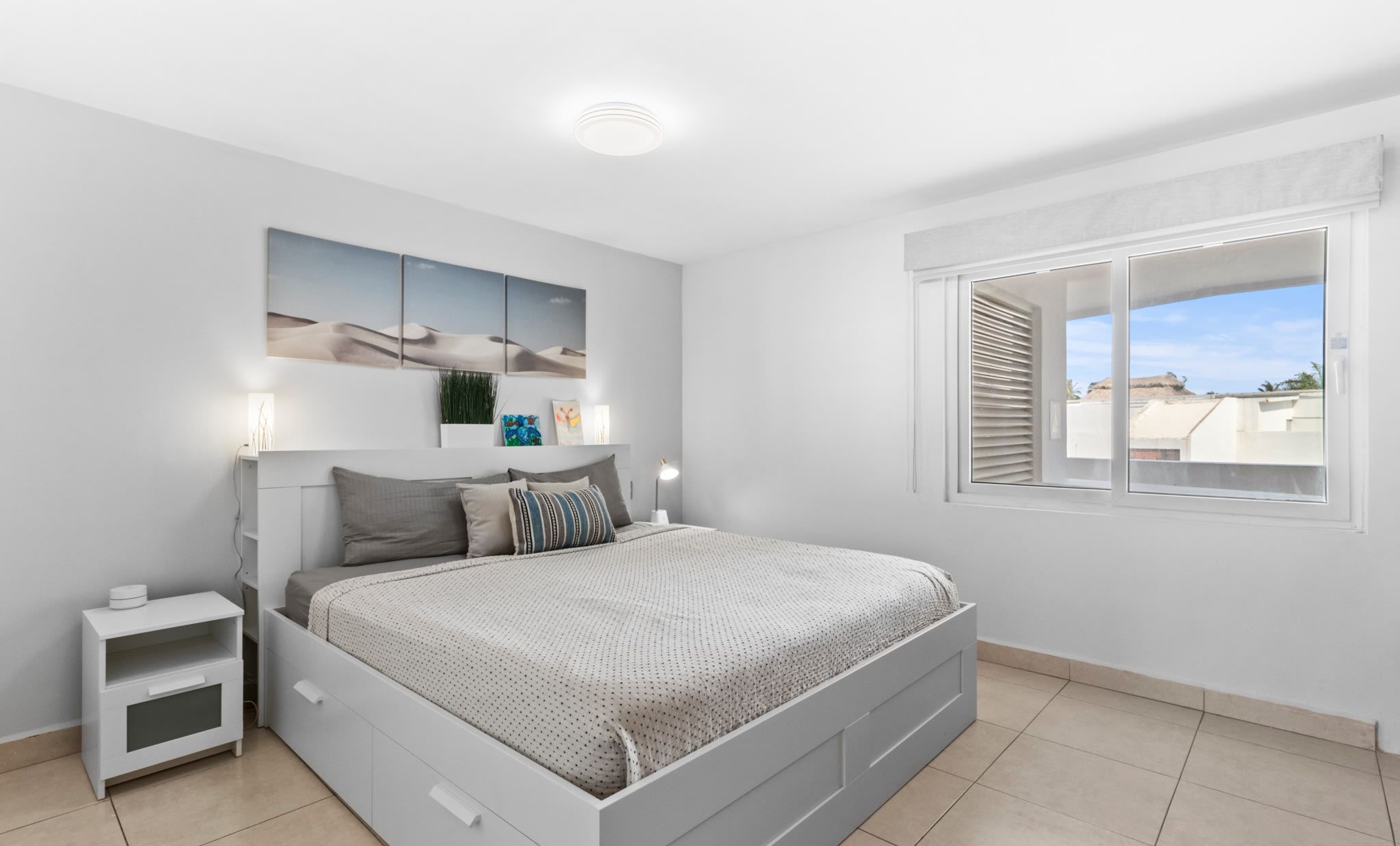 Una camera da letto moderna con un letto grande, comodini, un tavolino di fianco al letto e una lampada a soffitto.