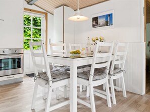 Enjoy meals in this kitchen with a stainless steel oven, dining table, and comfortable seating for four.