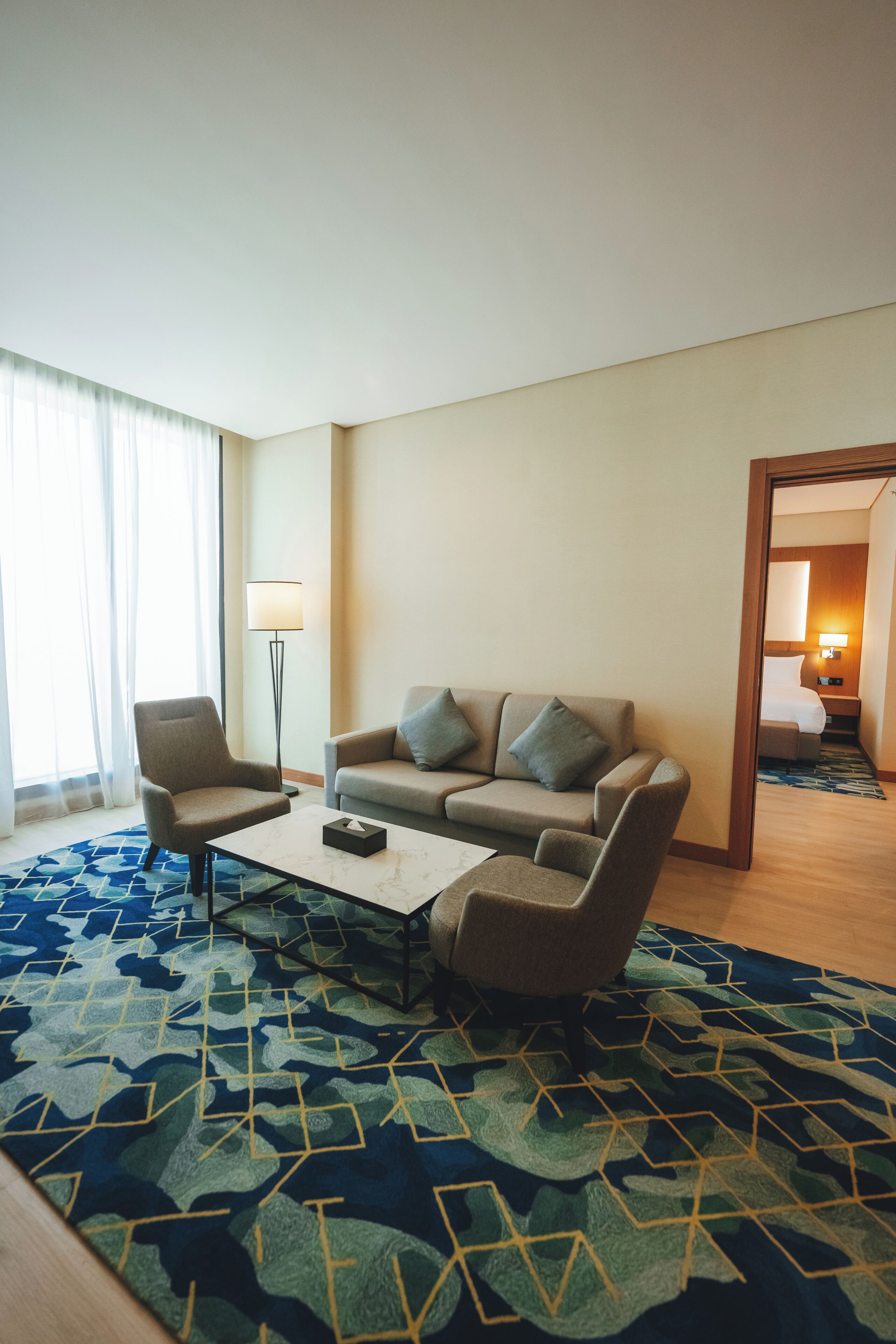 Una habitación de hotel con sofá, sillón y una mesa de centro.