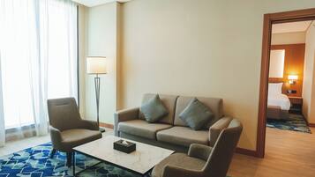 Una habitación de hotel con sofá, sillón y una mesa de centro.