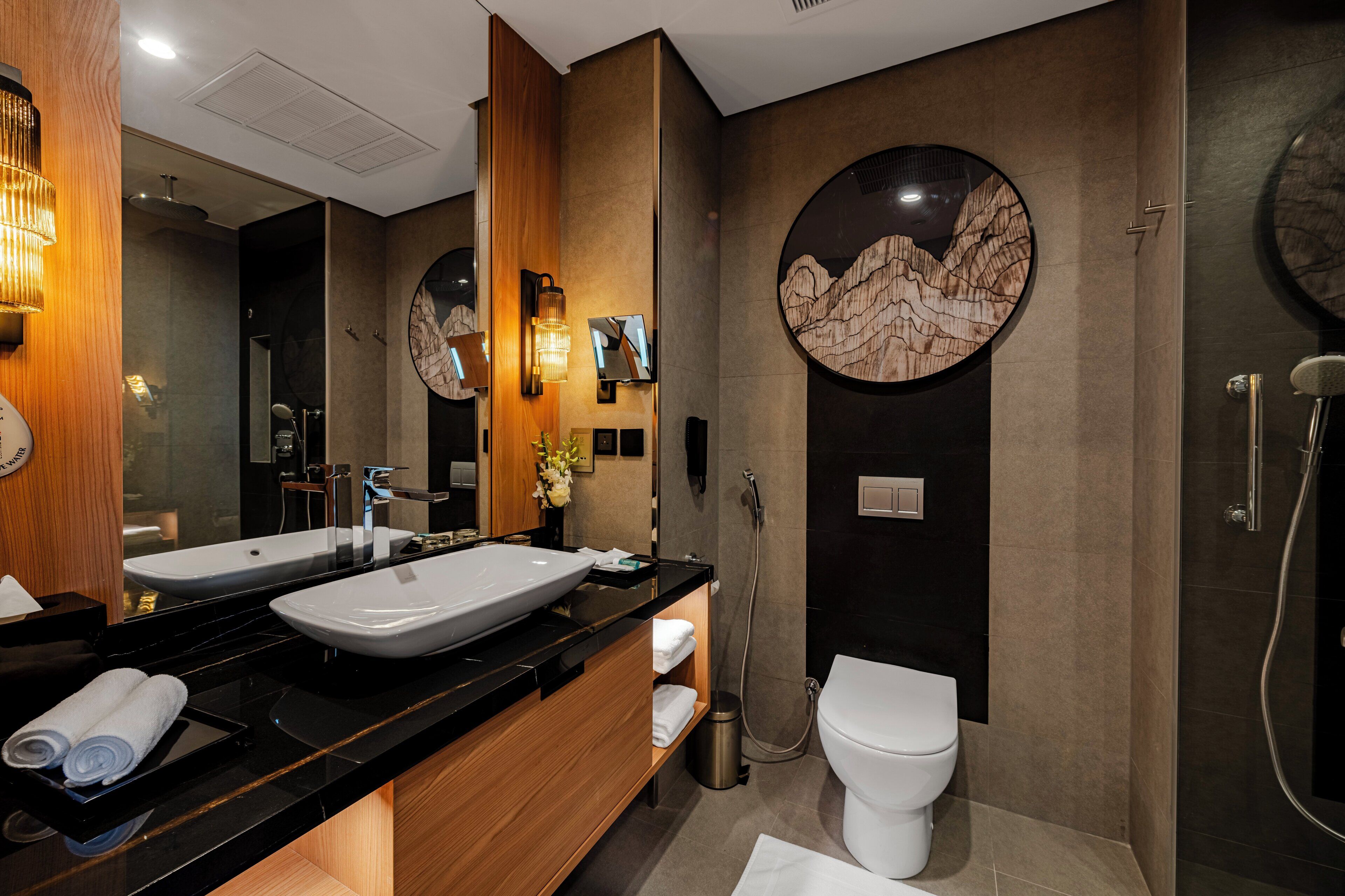 Une salle de bain moderne avec deux lavabos, des toilettes et une douche.