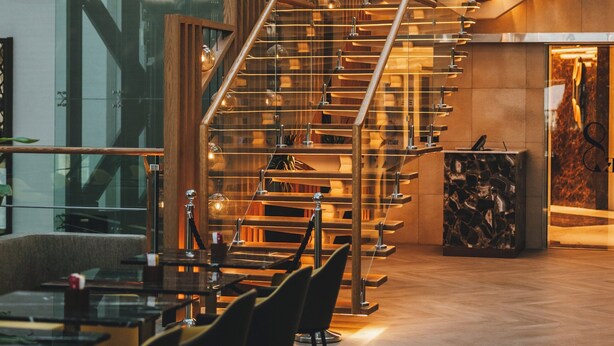 A modern interior with a spiral staircase, wooden accents, and a glass wall. - Millennium Al Masar Hotel (Jeddah)
