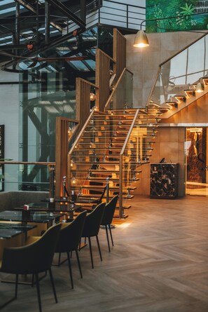 A modern interior with a spiral staircase, wooden accents, and a glass wall. - Millennium Al Masar Hotel (Jeddah)