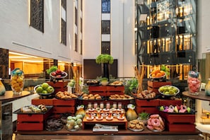 Ein reichhaltiges Buffet mit verschiedenen Speisen und Getränken, präsentiert auf Holztischen und -ständern.