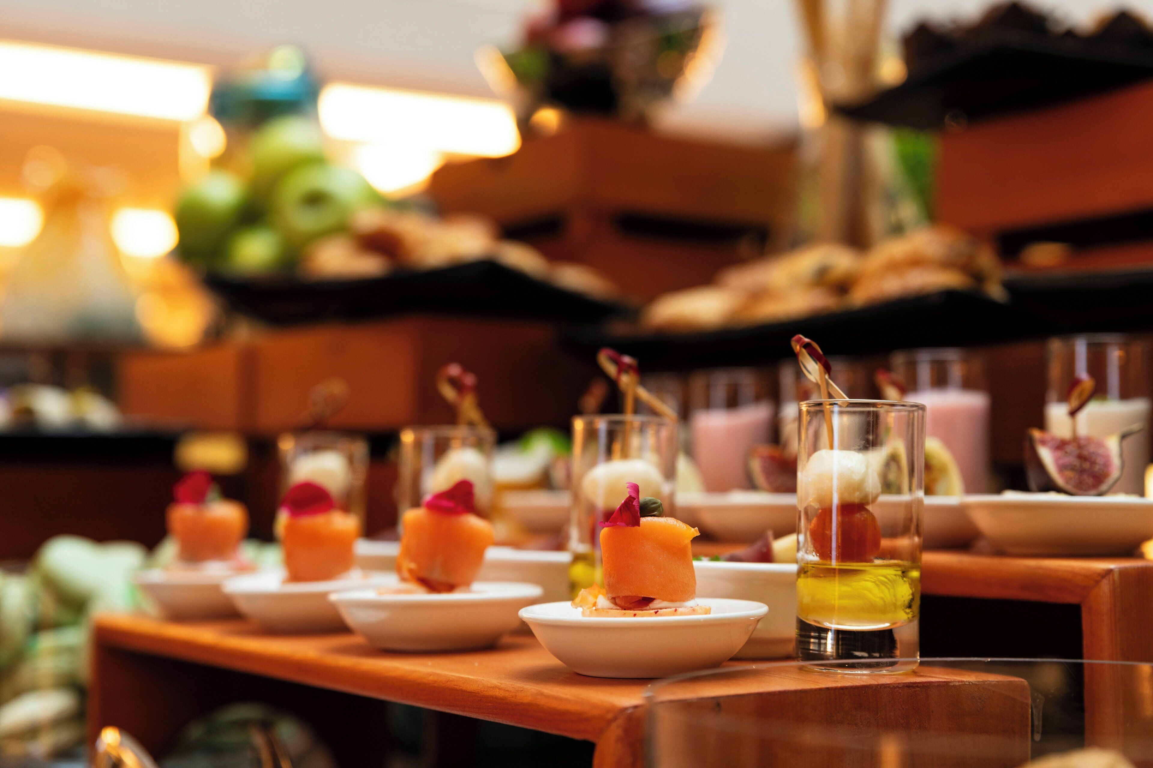Une table de desserts proposant divers mets présentés individuellement et une sélection de boissons.