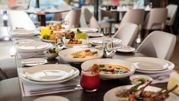 A restaurant table set with plates, glasses, and various dishes.