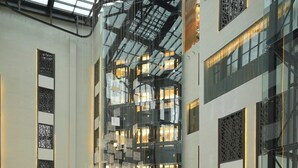 A modern hotel lobby with a large TV screen, multiple seating areas, and a glass atrium. - Millennium Al Masar Hotel (Jeddah)