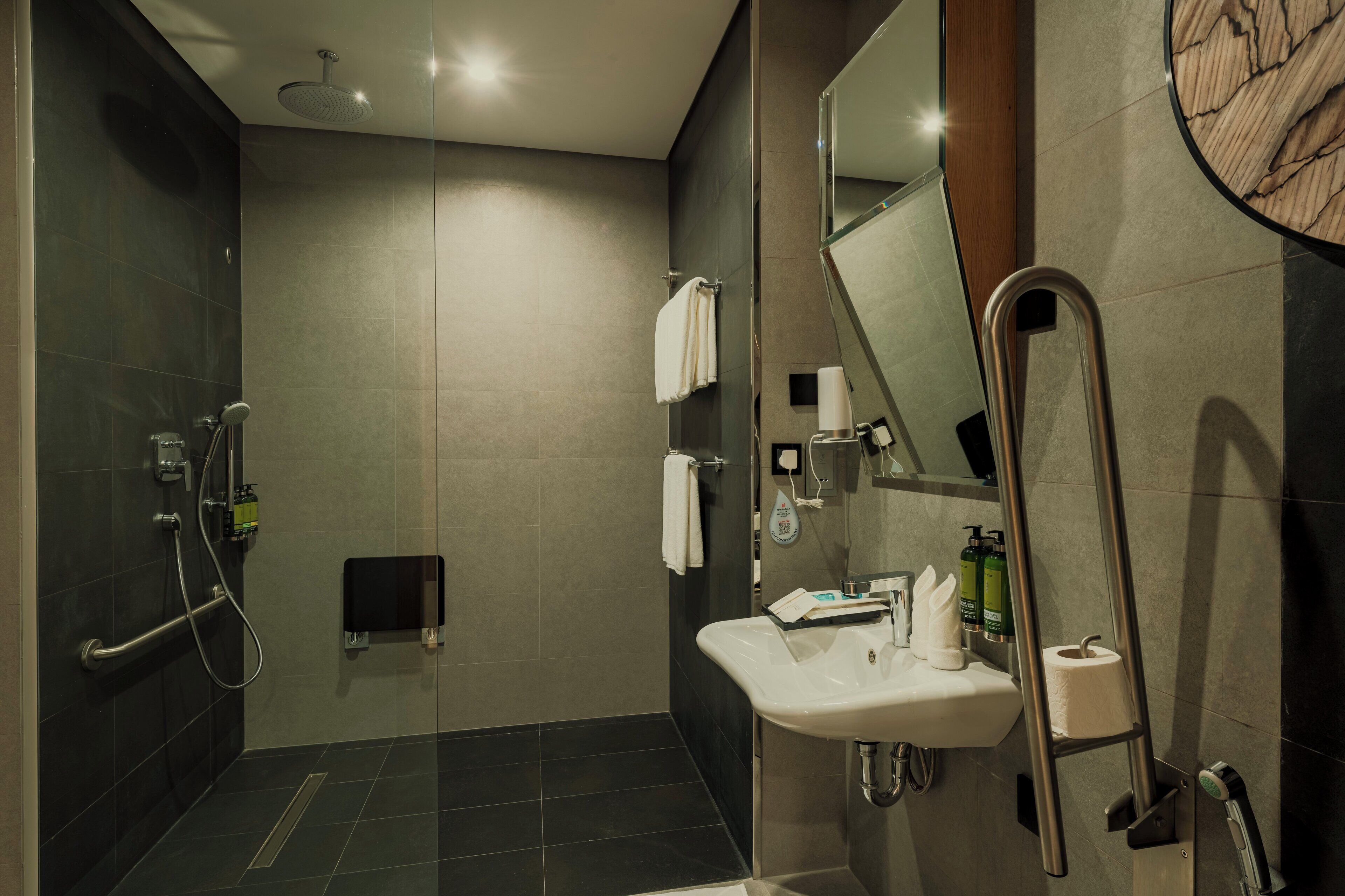 A modern bathroom with a shower, toilet, and sink.