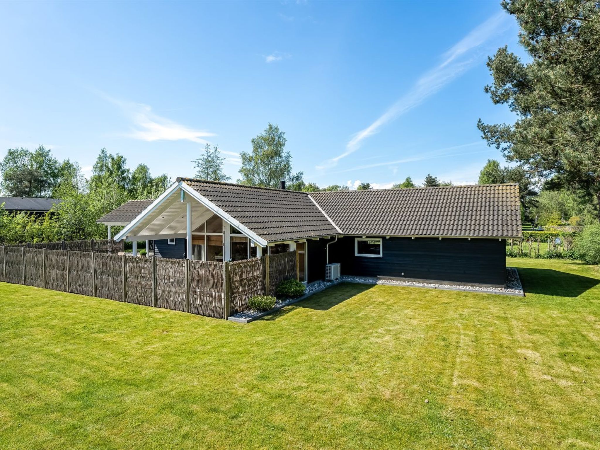 A two-story house with a fenced backyard, a covered porch, and a well-maintained lawn.