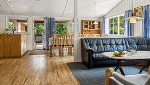 A spacious living area with a leather sofa, wooden dining table, and a kitchen area visible through an open door. - "Fritza" - 500m from the sea by Interhome (Fårevejle)