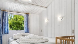 A bedroom with a bed, a crib, a window with curtains, and wall-mounted lights. - "Fritza" - 500m from the sea by Interhome (Fårevejle)