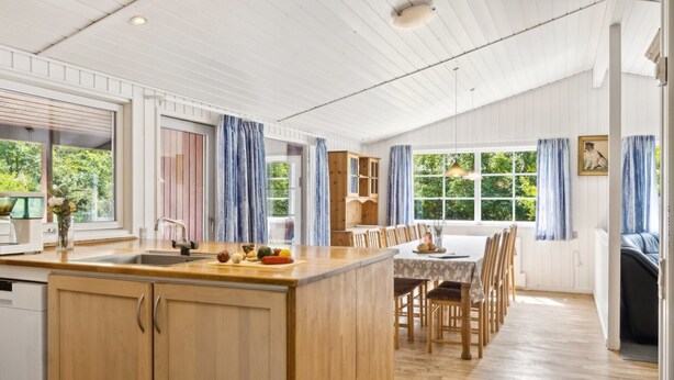 A spacious kitchen with wooden cabinets, a central island, and a dining area with a table and chairs. - "Fritza" - 500m from the sea by Interhome (Fårevejle)