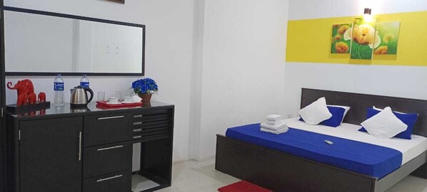 Ein Schlafzimmer mit einem Bett, einem Schminktisch, einem Spiegel und einer Wand mit einem Gemälde.