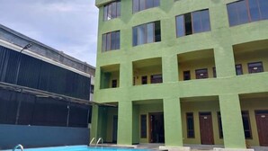 Un immeuble à plusieurs étages avec une piscine située à l’avant.