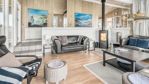 A modern living room with a fireplace, leather sofas, and wooden flooring.