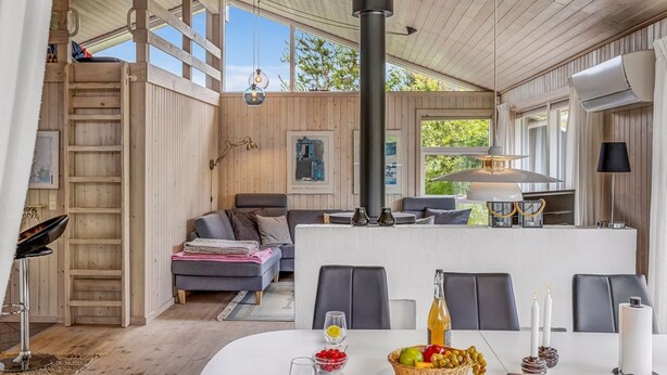 A modern interior with a dining area, a sofa, and a large window. - "Anouk" - 2km from the sea by Interhome (Saltum)