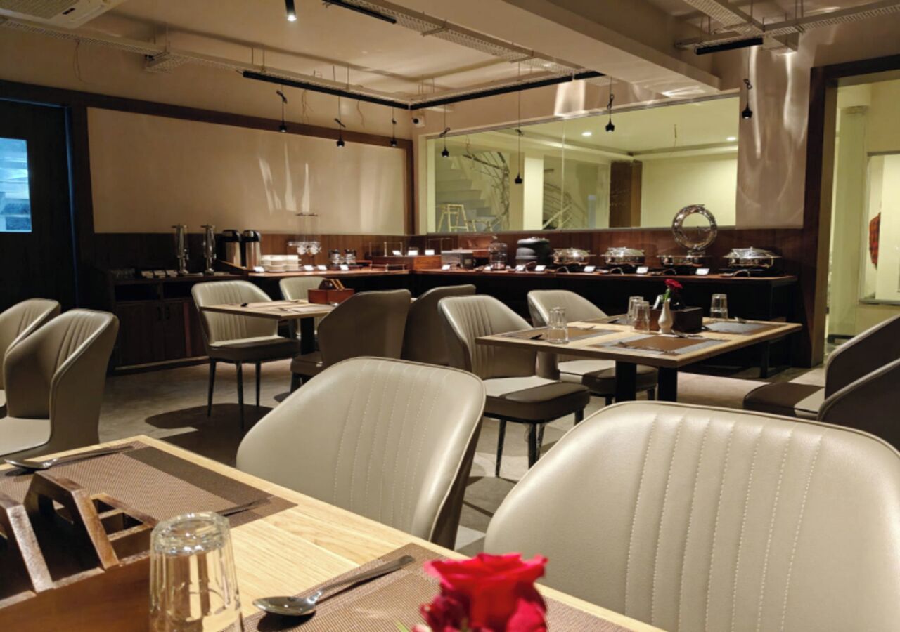 Un espace repas moderne avec des chaises en cuir, des tables en bois et un buffet.