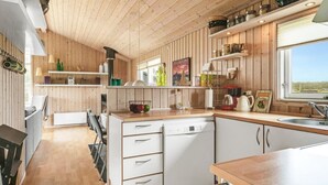 A modern kitchen with wooden paneling, white cabinets, and a wooden countertop. - "Niesina" - 200m from the sea by Interhome (Løkken)