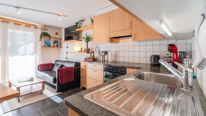 A modern kitchen with wooden cabinets, a built-in oven, and a stainless steel sink. - Haus Judith - Bonita by Interhome (Saas-Fee)