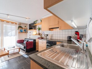 Kjøleskap, høy barnestol og kjøkkenutstyr