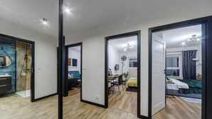 Une chambre d’hôtel moderne avec un plancher en bois, un lit, un bureau et une chaise.