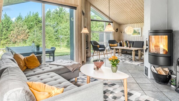 Een moderne woonkamer met een grote bank, een eettafel en een open haard.