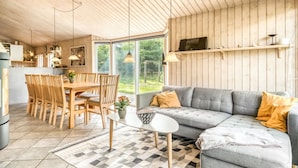 Een modern interieur met een eethoek, bank en keuken.