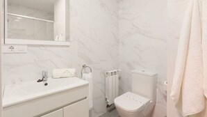 A bathroom with a white sink, mirror, toilet, and a towel rack. - 644C2 Apartamentos Sobrecantu (Oviedo)