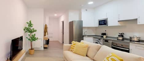 Una sala de estar moderna con un sofá, un televisor y una planta.