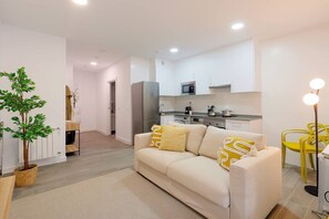 A modern apartment with a living room, kitchen, and dining area.