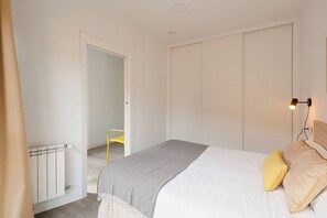 Un dormitorio con cama, radiador, puerta y lámpara.