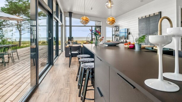 A modern kitchen with a large island, bar stools, and pendant lighting. - "Rakita" - 75m from the sea by Interhome (Sjællands Odde)