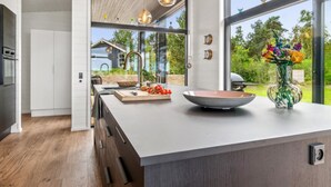 A modern kitchen with a large island, wooden cabinets, and a view of the outdoors. - "Rakita" - 75m from the sea by Interhome (Sjællands Odde)