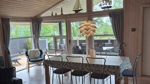 A dining area with a table, chairs, and a view of the outdoors. - Cozy summer house and annex in tranquility (Glesborg)