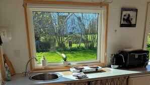 A compact kitchen with a window, a toaster, and a sink. - Charming summer house in an idyllic area. (Odder Gylling)