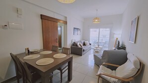 Una sala de estar moderna con comedor, sofá y balcón con vistas.