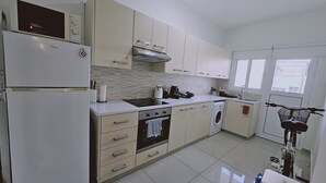 Una cocina moderna con refrigerador, estufa, lavaplatos y lavadora.