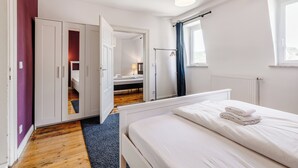 A bedroom with a bed, a wardrobe, a radiator, and a window. - Cozy apartment in the heart of Kulmbach (Kulmbach)