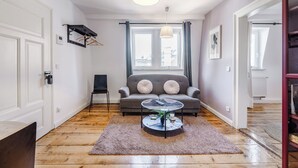 A modern living room with a grey sofa, a round coffee table, and a hanging light fixture. - Cozy apartment in the heart of Kulmbach (Kulmbach)
