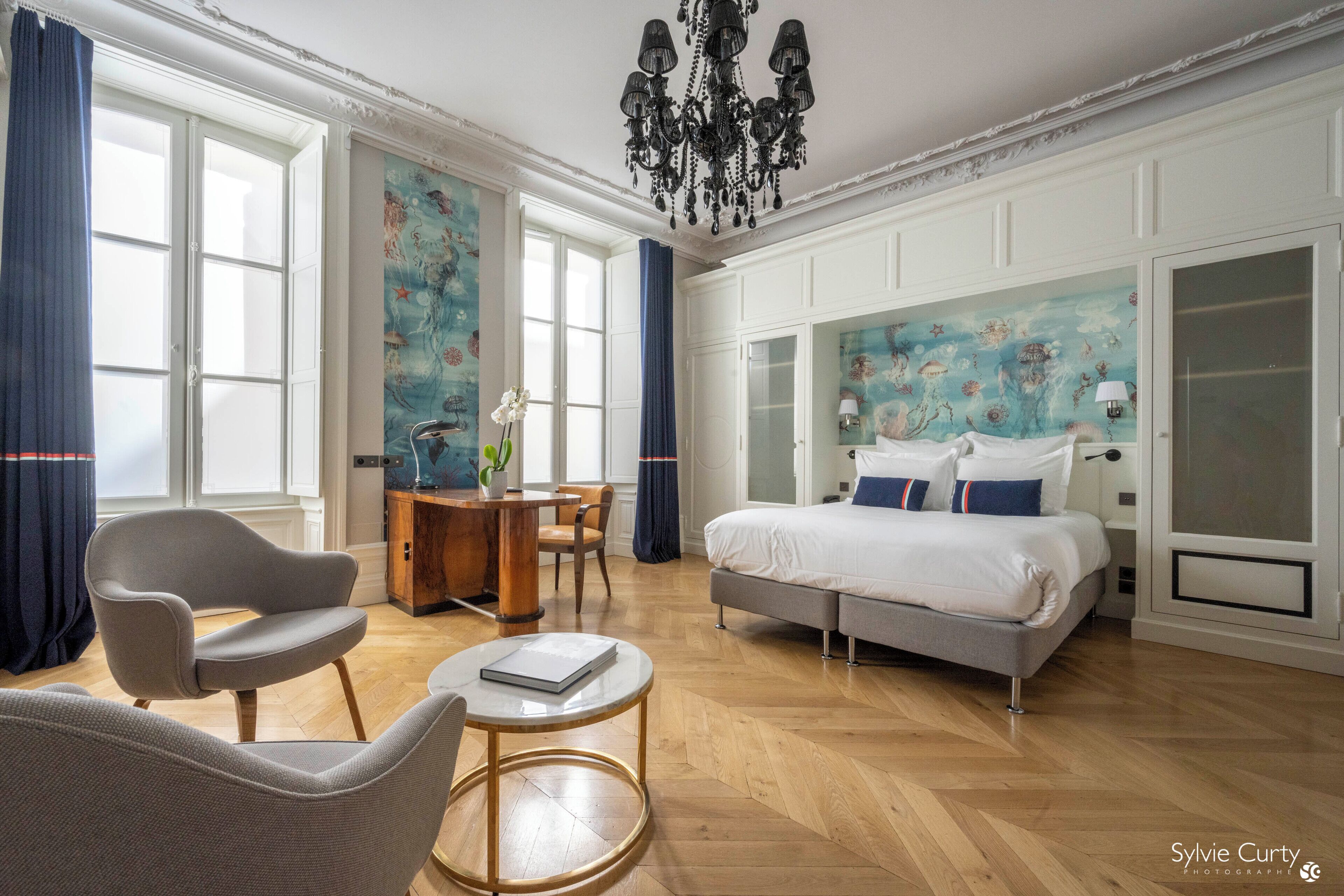 A modern bedroom with a bed, a desk, and a chair.